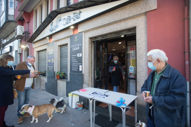 Un establecemento serve cafés para levar o mesmo día da entrada en vigor de novas restricións impostas pola crise do Covid-19 no municipio de Vilalba, Lugo.