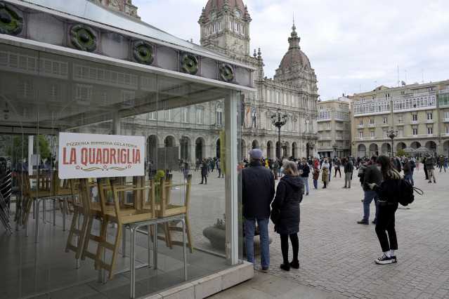Grupos de persoas concéntranse en fila da catro na praza de María Pita contra as restricións impostas ao sector hostaleiro, na Coruña