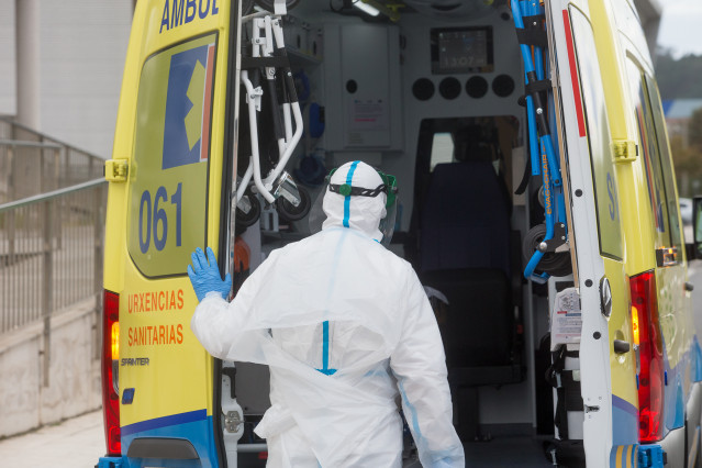 Un traballador sanitario totalmente protexido pecha a porta dunha ambulancia tras recoller a un ancián da residencia de anciáns de San Cibrao onde se orixinou un brote de Covid-19, en San Cibrao, Lugo, Galicia, (España), ao 9 de novembro de 20