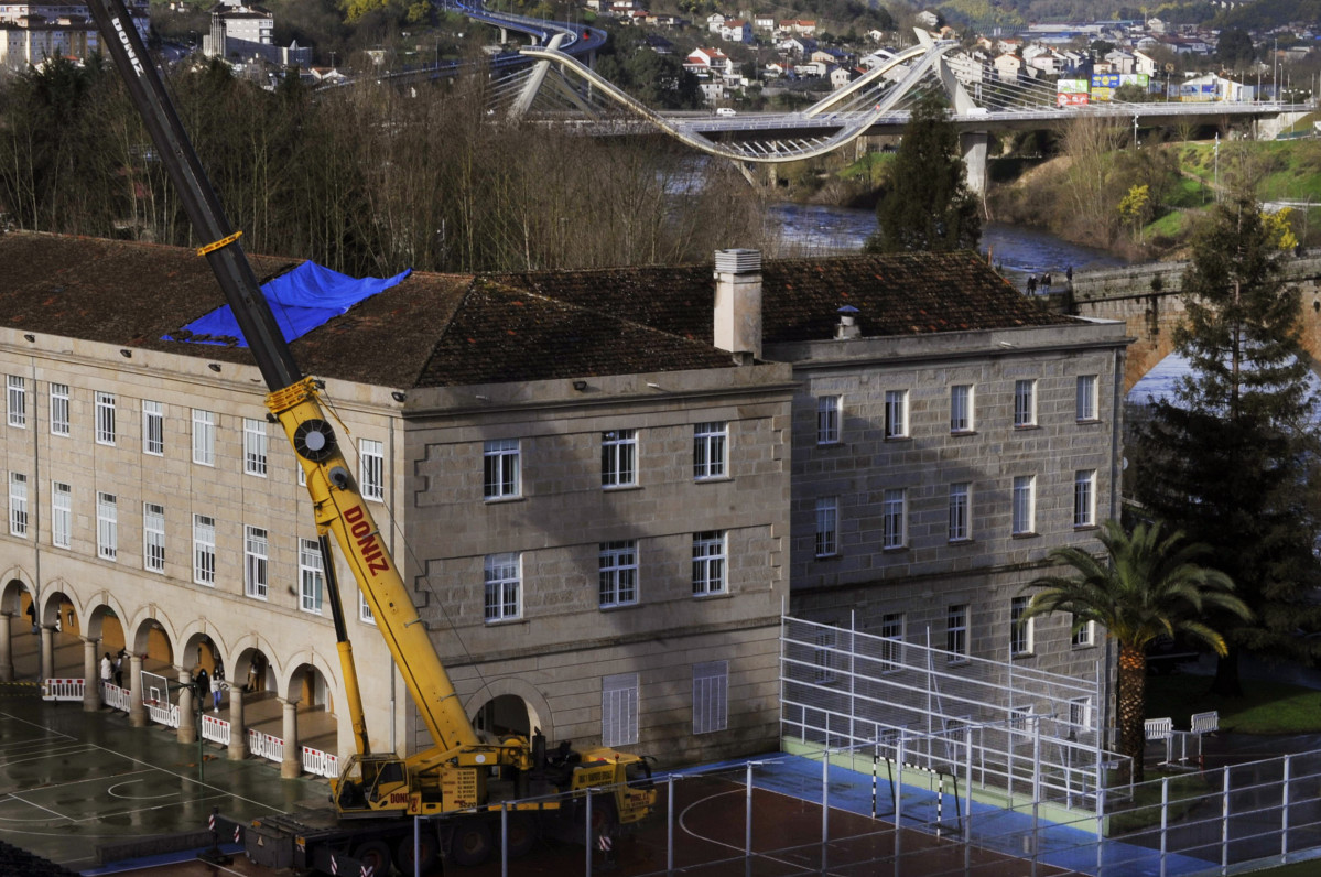 Un guindastre intervén nos traballos de reparación do tellado do colexio dos Salesianos de Ourense, Galicia (España), ao 3 de febreiro de 2021.