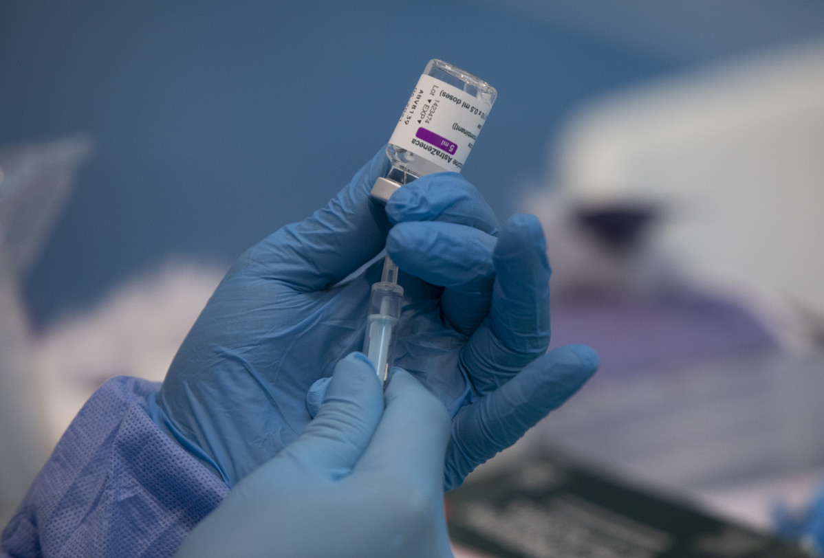 Unha profesional sanitaria sostén unha xiringa cun vial da vacina contra a Covid-19 de AstraZeneca nun dispositivo de vacinación no pavillón SADUS en Sevilla (Andalucía, España), a