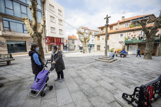 Dúas mulleres conversan nunha praza do Grove, o día en que entra en vigor o peche perimetral do municipio, ao 8 de abril de 2021, no Grove, Pontevedra, Galicia, (España).  O Comité Clínico da Xunta de Galicia decretou este martes o peche p
