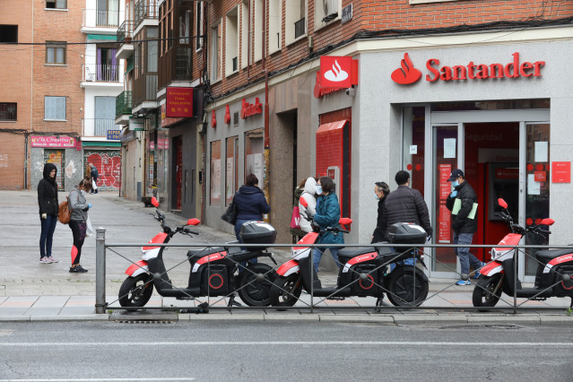Arquivo - Varias persoas esperan para entrar a unha oficina do Banco Santander durante o inicio da cuarta semana do estado de alarma decretado como consecuencia do coronavirus. En Madrid (España), ao 6 de abril de 2020.