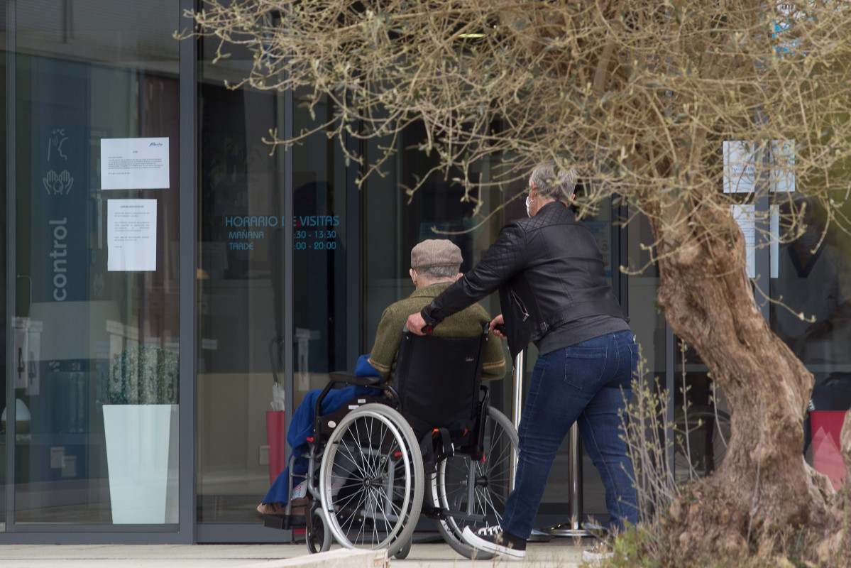 Arquivo - Unha muller pasea xunto a un ancián en cadeira de rodas cara á residencia Albertia, ao 17 de abril de 2021, en Lugo, Galicia (España). Unha das novas medidas incluídas na desescalada d