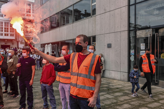 Un home sostén unha bengala nunha concentración de apoio aos traballadores da fábrica de Vestas de Viveiro (Lugo) polo peche inminente da planta, na praza do Concello de Viveiro, ao 25 de setembro de 2021, en Viveiro.