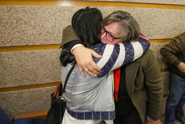 A alcaldesa do Porriño, Eva García de la Torre (d), abrázase a unha muller á súa chegada a unha comparecencia para anunciar a súa dimisión, no Salón de sesións do Concello, ao 23 de novembro de 2021, no Porriño (Pontevedra)