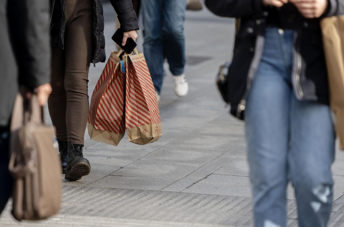 Una mujer camina con bolsas con compras, a 25 de noviembre de 2021, en Madrid (España). El Black Friday se celebra después del día de Acción de Gracias y se caracteriza por que en él se lanzan of