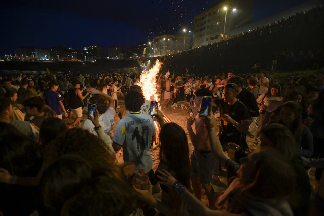 Centenares de persoas fronte a unha fogueira na Noite de San Juan, ao 23 de xuño de 2022, na Coruña, Galicia (España).