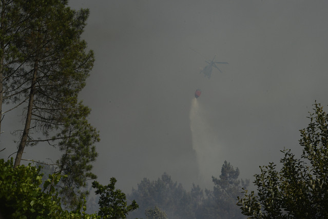 Un helicóptero traballa na extinción dun incendio, ao 27 de xullo de 2022, en Castrelo de Miño, Ourense, Galicia (España). O incendio forestal ha queimado unhas seis hectáreas, segundo estimación provisional de Medio Rural. A Consellería informa que o f