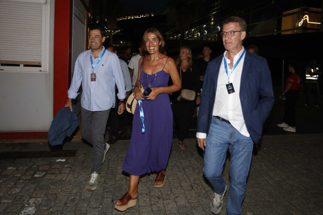 O presidente da Junta de Andalucía, Juanma Moreno (i1); a empresaria Eva Cárdenas, esposa de Alberto Núñez Feijóo; e o presidente do PP, Alberto Núñez Feijóo; asisten ao concerto do cantante C Tangana, no peirao de Transatlánticos de Vigo, a 23