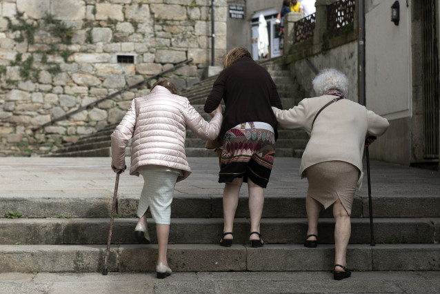 Arquivo - Persoas maiores camiñan por unha rúa en Galicia. Alivio familiar.