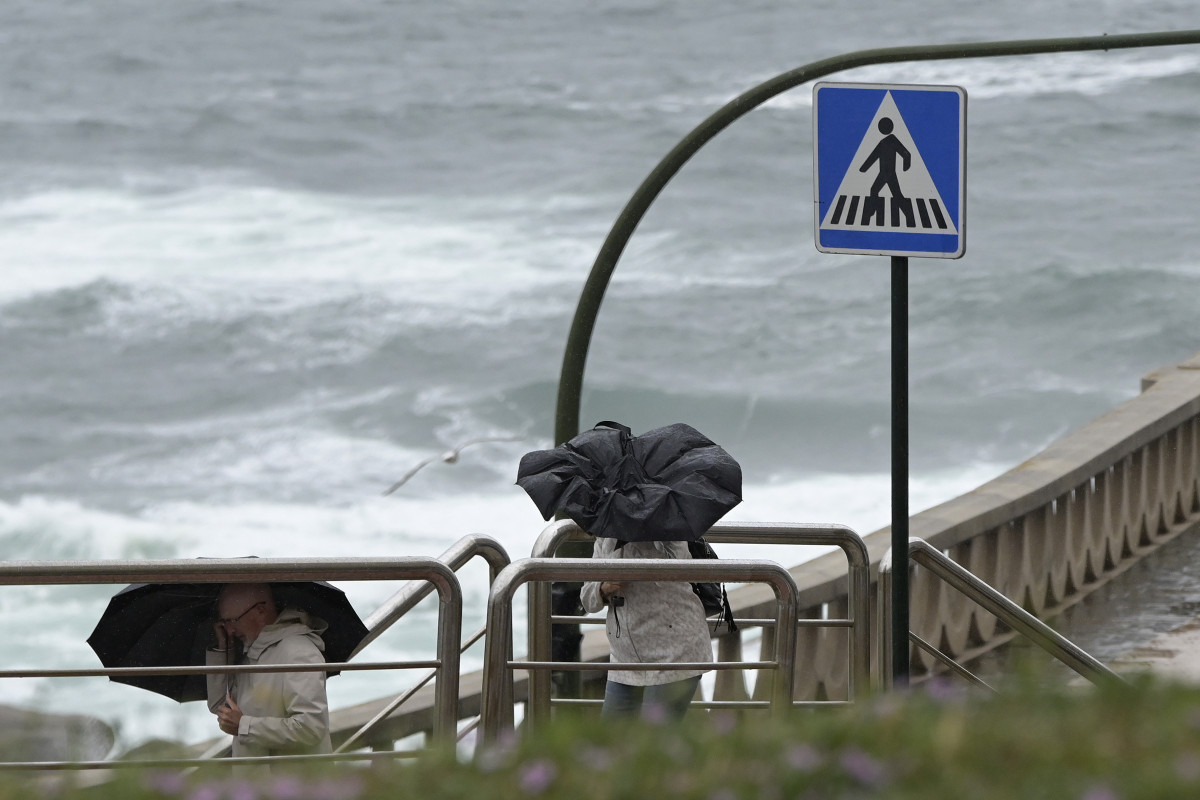 Archivo - Dos personas con paraguas caminan por el Paseo Marítimo de A Coruña, a 19 de junio de 2022, en A Coruña, Galicia.