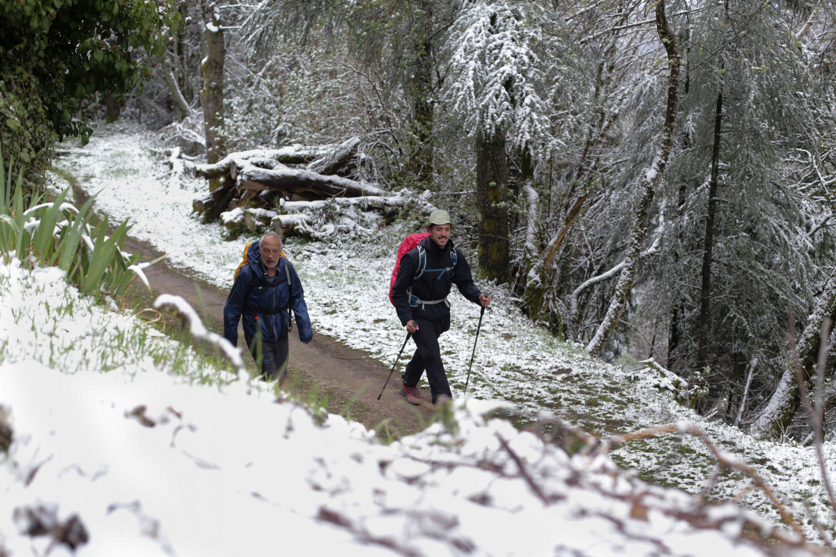 Archivo - Dos peregrinos caminan en la nieve por el pueblo prerromano de O Cebreiro, a 20 de abril de 2022, en O Cebreiro, Lugo, Galicia (España). Después de una Semana Santa con altas temperaturas 