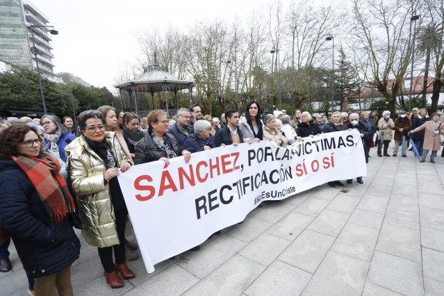 El presidente del PP de Ferrol, José Manuel Rey Varela (5i), y la secretaria general del PP gallego, Paula Prado (c), sujetan una pancarta que reza 'Sánchez, por las víctimas, rectificación sí o sí NoEsUnChiste' durante la concentración convocada por el