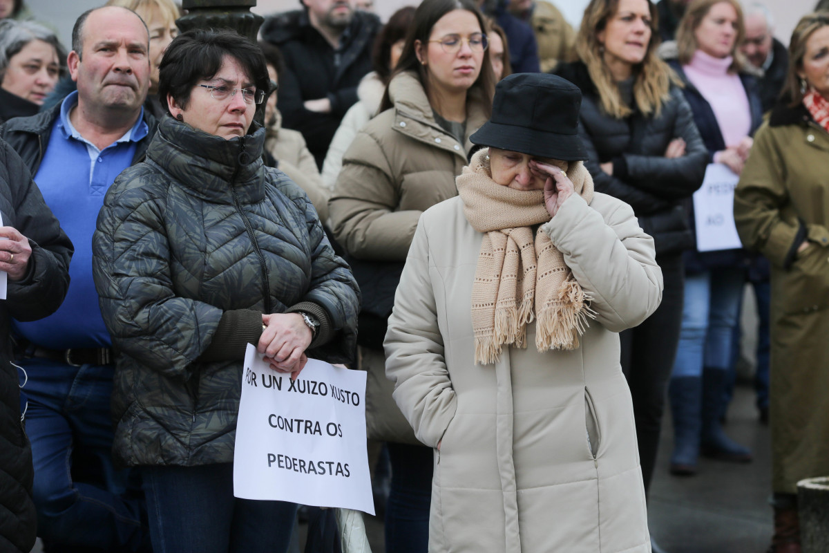 Una mujer con un cartel en la mano en una concentración de repulsa por el caso de la niña violada en Baleira, a 21 de enero de 2023, en Baleira, Lugo, Galicia (España). Tres personas han sido conde