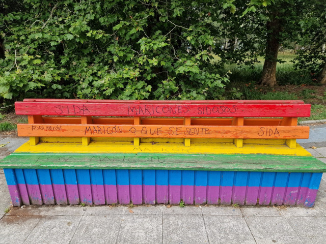 Pintadas homófobas en un banco pintado con la bandera arcoiris