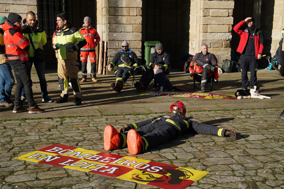 Un muñeco vestido de bombero en suelo durante una concentración en forma de protesta pacífica, en la Praza do Obradoiro, a 15 de diciembre de 2023, en Santiago de Compostela, A Coruña, Galicia (Es