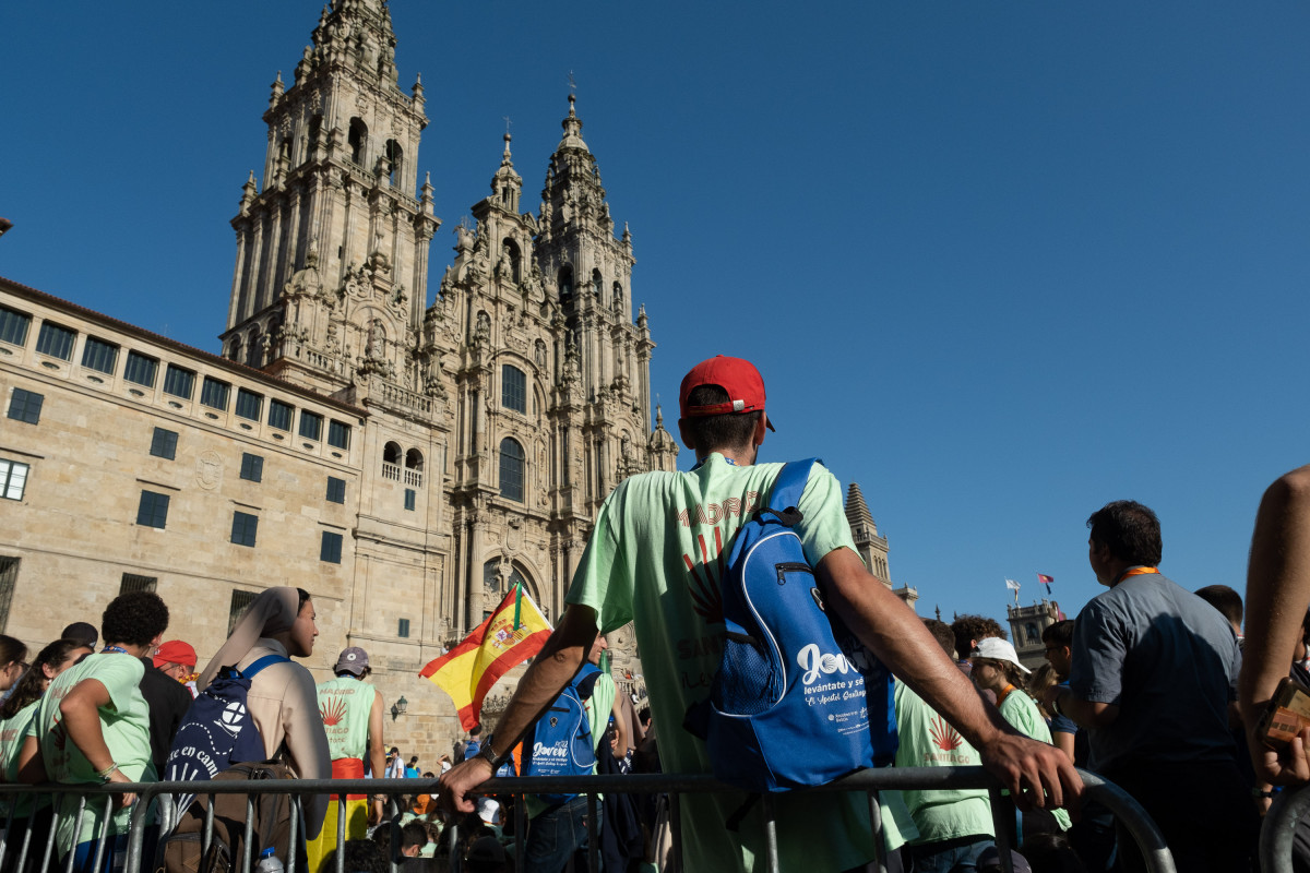 Archivo - Turistas sentados ante la Catedral de Santiago.