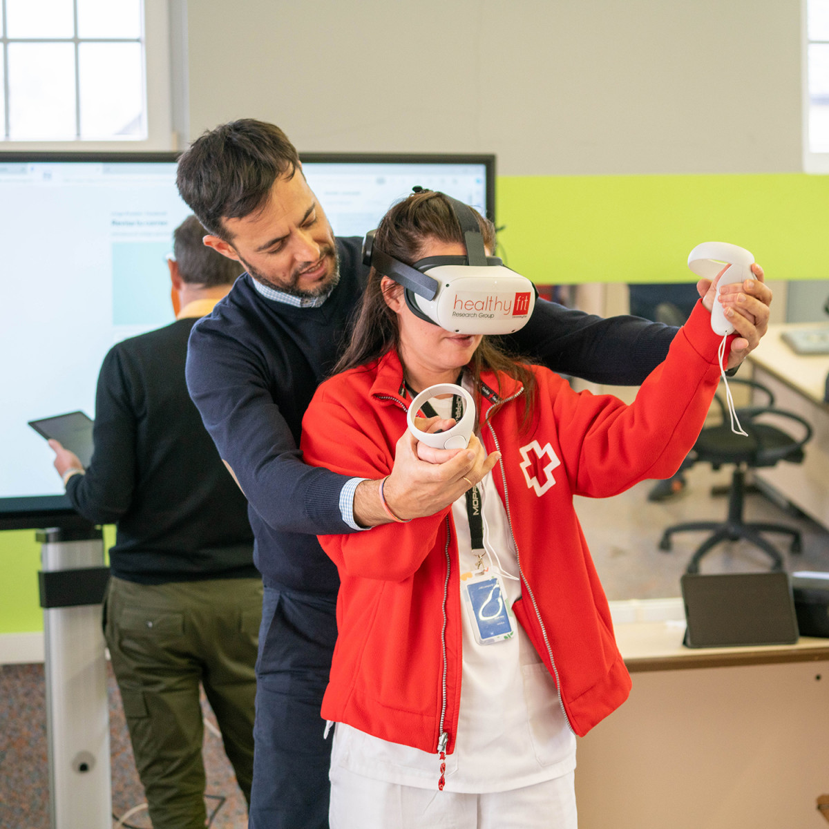Investigador de la UVigo enseu00f1ando a manejar un exergame a una voluntaria de la Cruz Roja