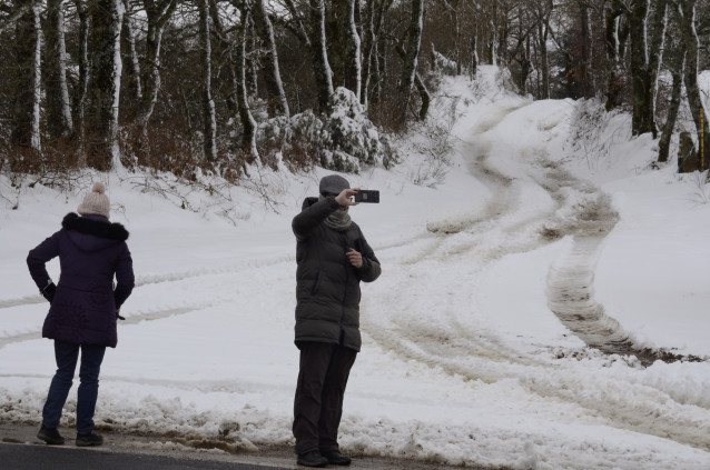 Dos personas observan la nieve, a 24 de febrero de 2024, en Montederramo, Ourense, Galicia (España). La Agencia Estatal de Meteorología (AEMET) ha avisado de riesgo por nieve en la provincia de Ourense, y se espera que las temperaturas mínimas bajen de 0