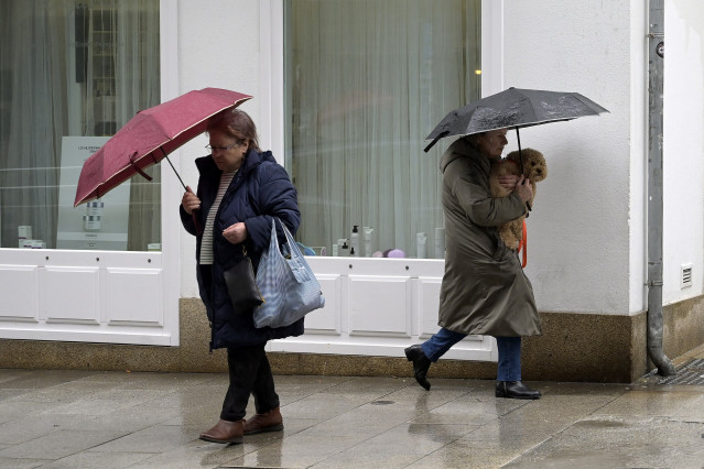 Archivo - Dos personas se refugian del viento con paraguas, a 8 de febrero de 2024, en A Coruña, Galicia (España). El paso de la borrasca Karlotta por Galicia está provocando a lo largo del día de hoy incidencias, lluvias copiosas y vientos de mucha inten