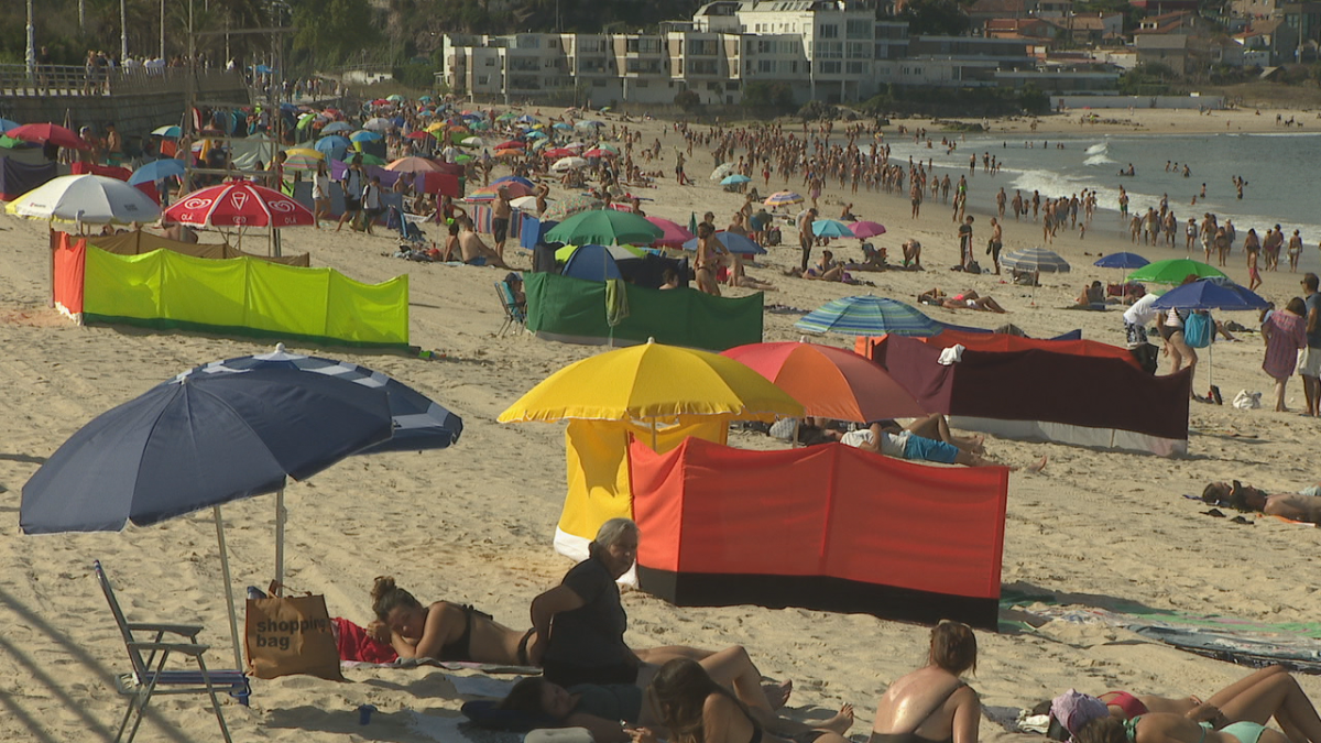 Bau00f1istas con paravientos en la playa de Samil en una imagen de CRTVG