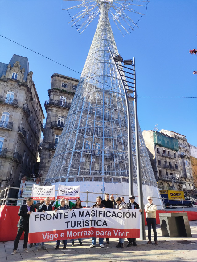 Integrantes de la Plataforma contra la Masificación Turística Vigo-O Morrazo, frente al árbol gigante de Navidad instalado en el centro de la ciudad olívica.